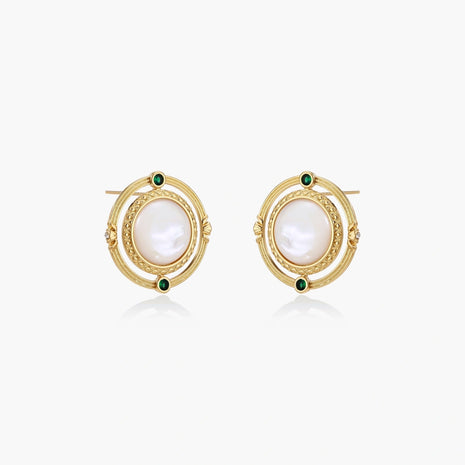 Circular gold stud earrings with iridescent mother-of-pearl center and green zirconia accents on cream background.