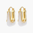 Sculptural gold-plated hoop earrings with flowing curved design and lever-back closure on cream background.