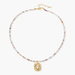 Ornate gold-plated pendant necklace with multicolored gemstone beads in purple, pink and clear tones on white background