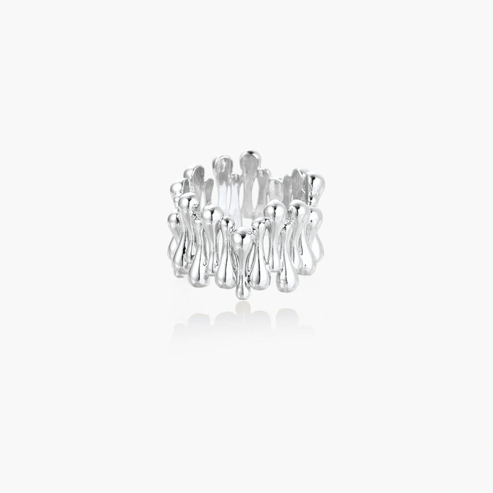 Wide band ring with sculptural wave ripples in polished white gold plated eco-brass on cream background