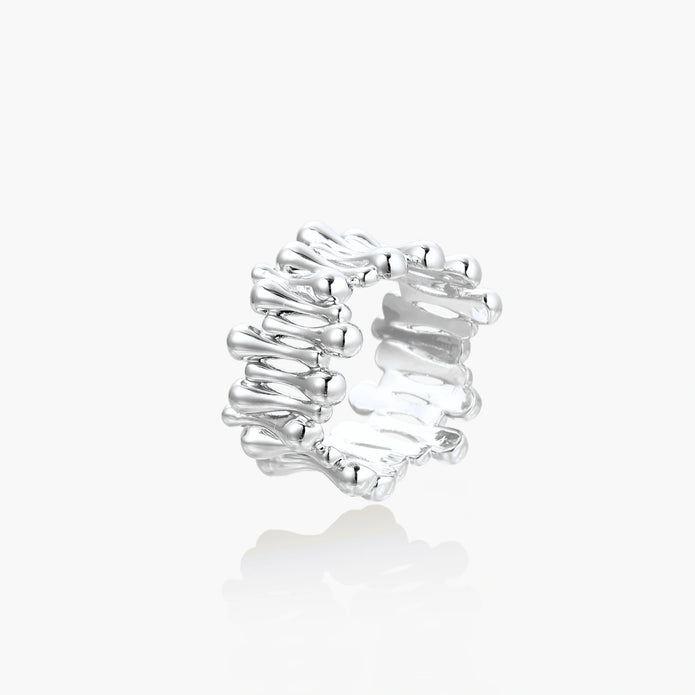 Wide band ring with sculptural wave ripples in polished white gold plated eco-brass on cream background