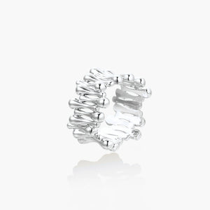 Wide band ring with sculptural wave ripples in polished white gold plated eco-brass on cream background