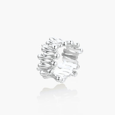 Wide band ring with sculptural wave ripples in polished white gold plated eco-brass on cream background