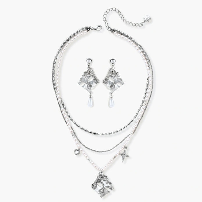 Ornate silver-toned masquerade mask jewelry set featuring rhinestone details and pearl drop earrings on white background.