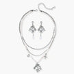 Ornate silver-toned masquerade mask jewelry set featuring rhinestone details and pearl drop earrings on white background.