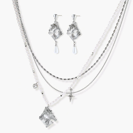 Ornate silver-toned masquerade mask jewelry set featuring rhinestone details and pearl drop earrings on white background.