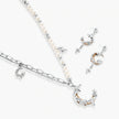 Mixed-metal jewelry set featuring layered necklaces with crescent moon pendant and pearl beads, plus matching star-drop earrings.