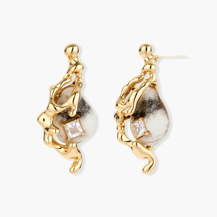 Close-up of metallic dragon-wrapped earrings with marbled resin stones on white background