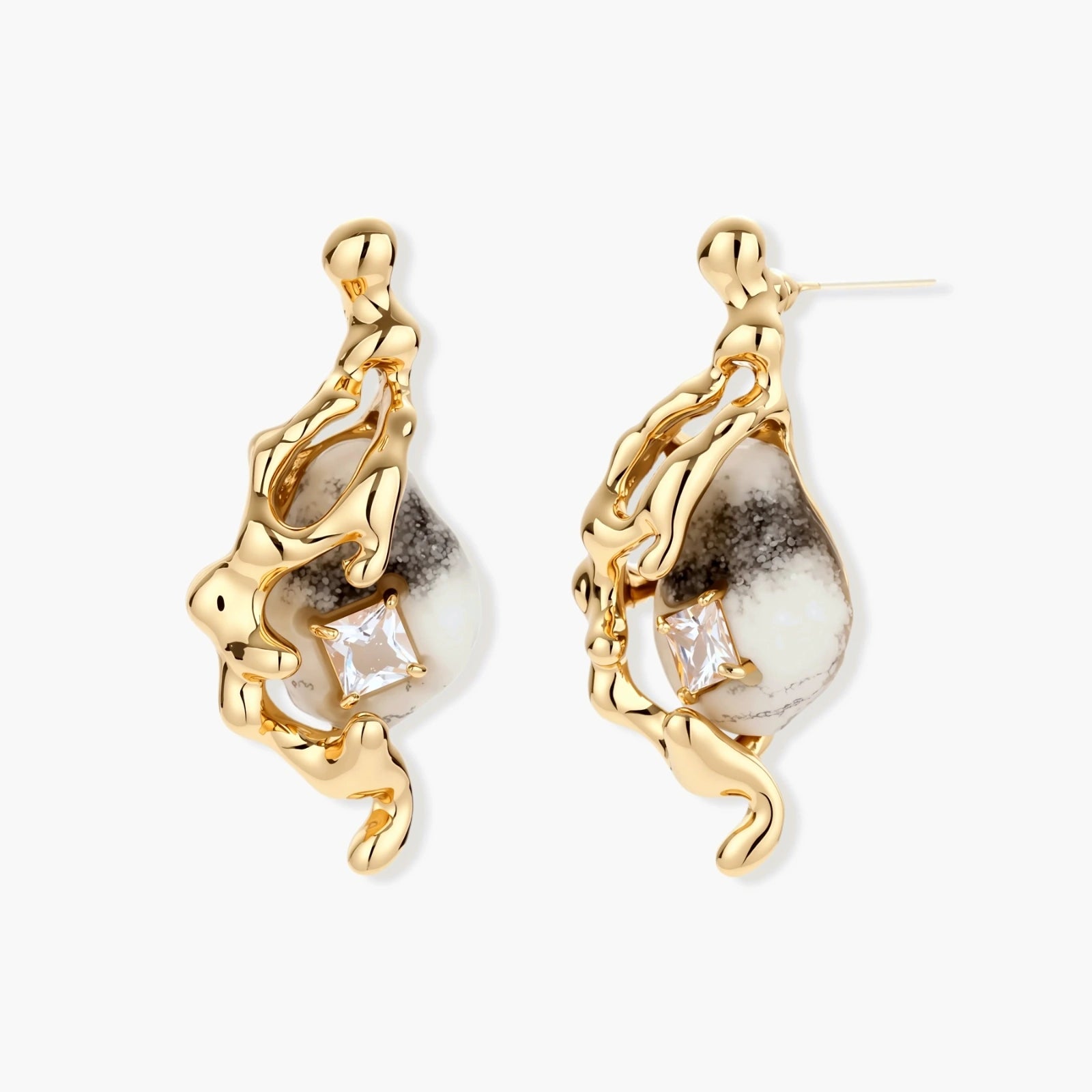 Close-up of metallic dragon-wrapped earrings with marbled resin stones on white background