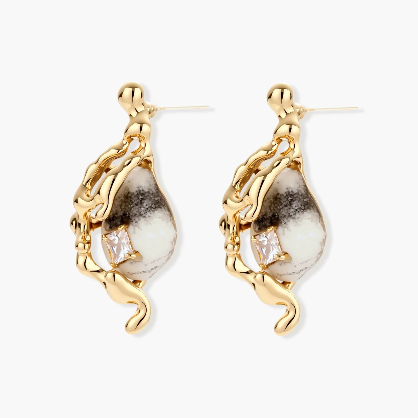Close-up of metallic dragon-wrapped earrings with marbled resin stones on white background