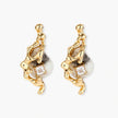 Close-up of metallic dragon-wrapped earrings with marbled resin stones on white background