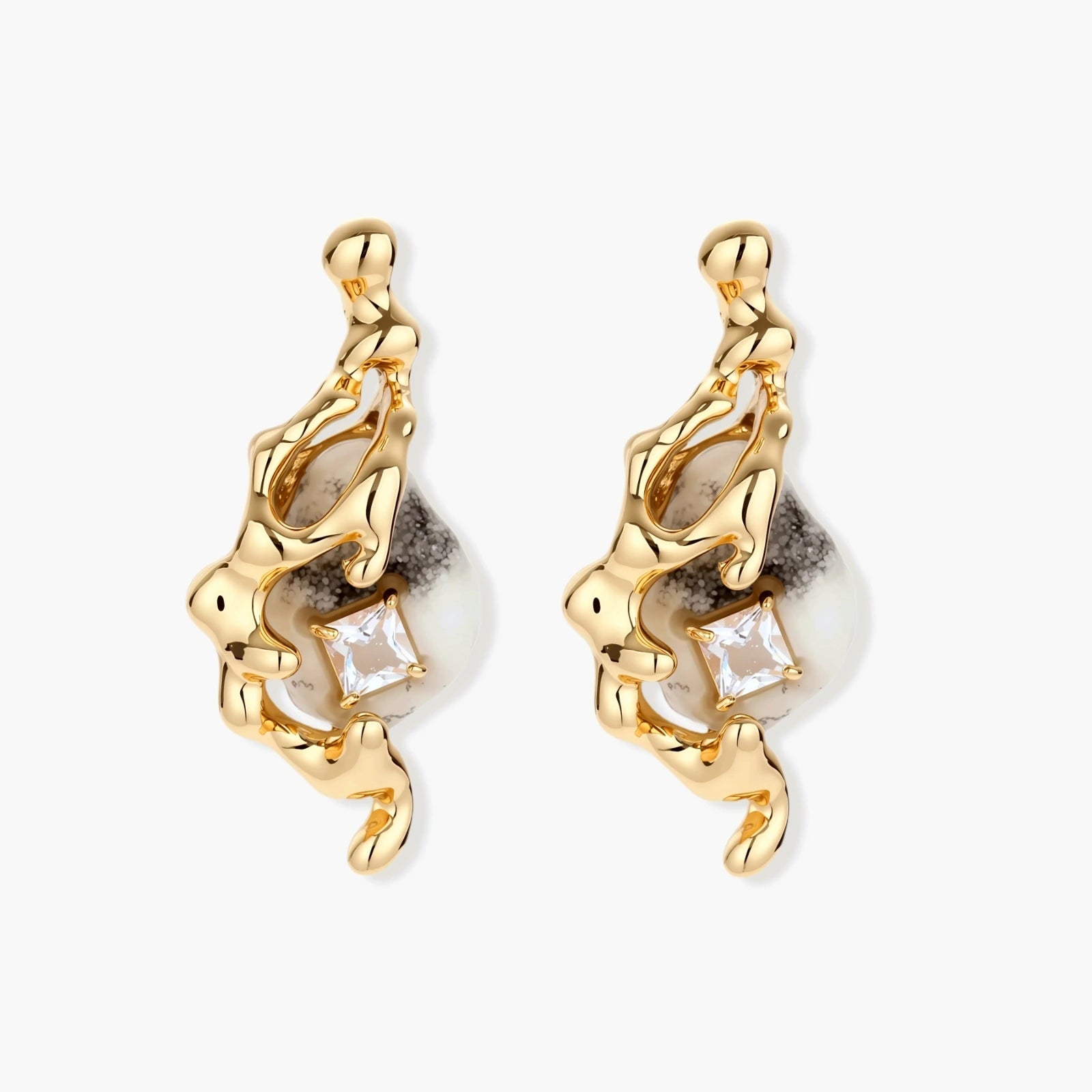 Close-up of metallic dragon-wrapped earrings with marbled resin stones on white background
