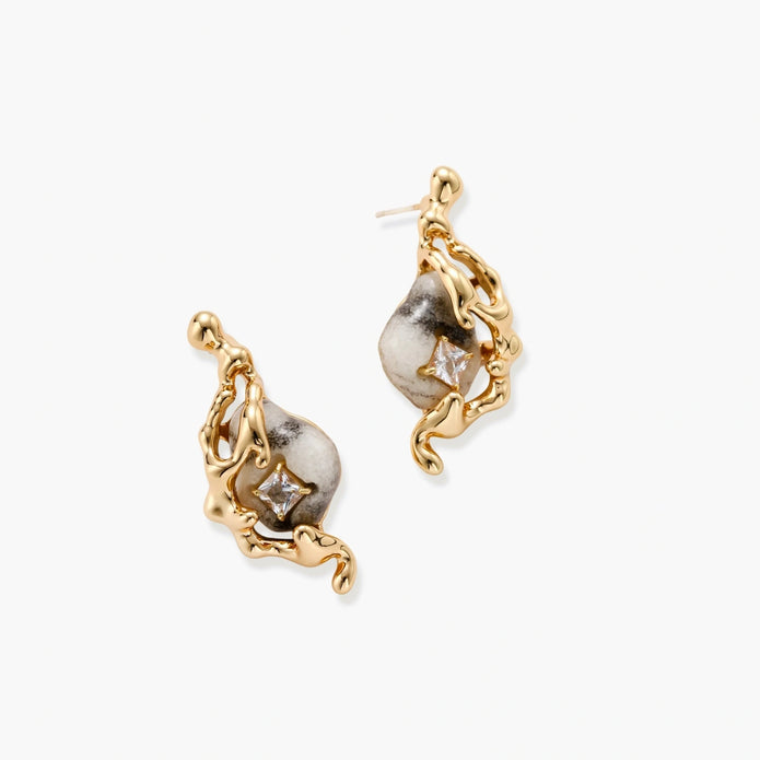 Close-up of metallic dragon-wrapped earrings with marbled resin stones on white background