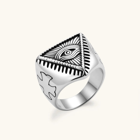 Silver stainless steel signet ring with engraved all-seeing eye in triangle, radiating lines, and cross motifs on the band.