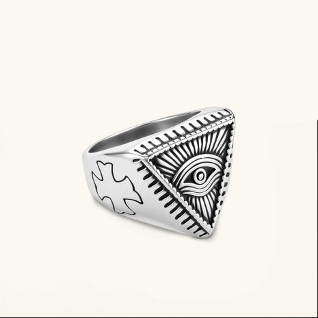 Silver stainless steel signet ring with engraved all-seeing eye in triangle, radiating lines, and cross motifs on the band.