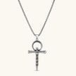 Silver stainless steel ankh pendant with skull motifs on vertical bar and textured ring top, on a box chain necklace.