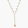 Adjustable gold lariat necklace with freshwater pearls nested in delicate cage settings and Y-shaped tassel drop