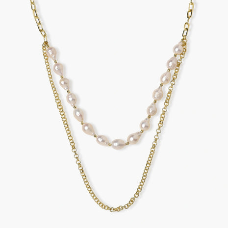 Layered gold chain necklace with organic baroque freshwater pearls and adjustable length on cream background