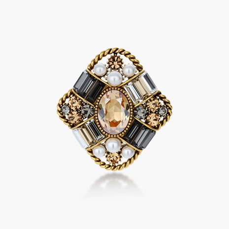 Ornate antique gold-plated brooch with central amber crystal, pearls, and zircon stones in baroque cross design