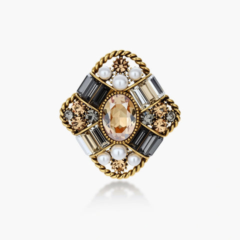 Ornate antique gold-plated brooch with central amber crystal, pearls, and zircon stones in baroque cross design