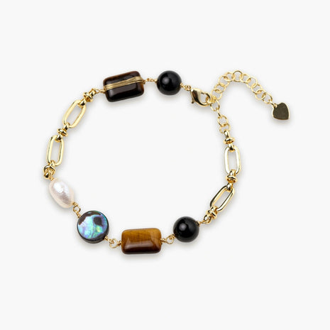 Gold chain bracelet with tiger's eye, obsidian, pearl, and iridescent abalone stones on cream background.
