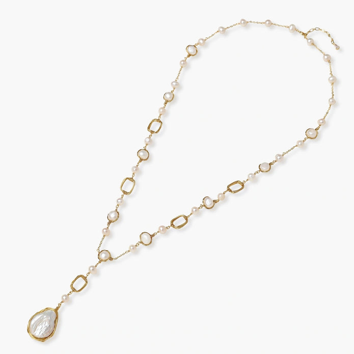 Long gold-plated necklace with alternating freshwater pearls and crystal bezels, featuring a large baroque pearl pendant